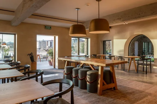 Indoor dining area with wooden furniture and a large open door leading to an outdoor patio