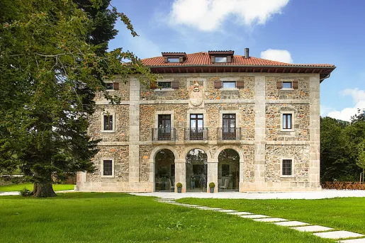 Exterior view of stone building with 3 large archways and small balconies above