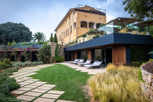 hotel with lots of outdoor seating and manicured gardens