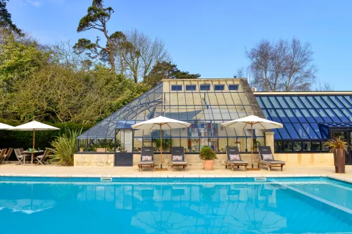 Outdoor pool next to a building with a glass roof