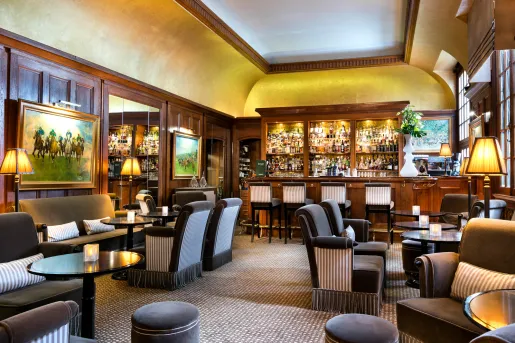 Indoor bar and lounge with black and white cushioned chairs and wooden walls