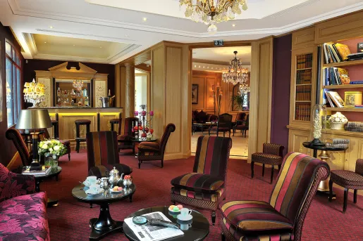 Indoor library, bar and lounge with red-striped cushioned chairs and circular tables