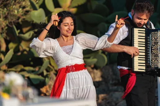 Woman dancing while man playing the accordion