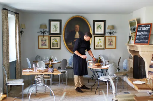 waiter setting table in dining room