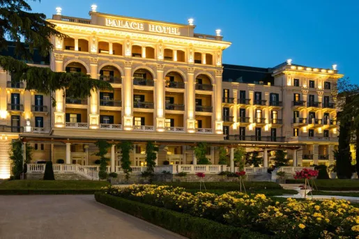 Large hotel building with columns and gardens out front