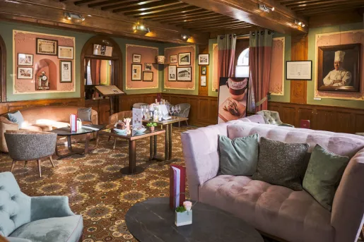 Indoor seating area with large, cushioned sofas and paintings on the wall