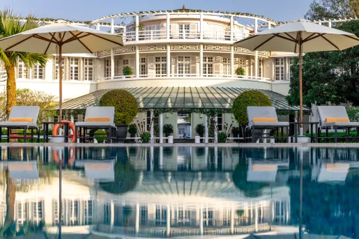 Exterior, wide view of white, castle-like building with balconies and an outdoor pool