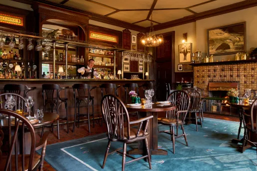 bartender behind the bar of dark wood