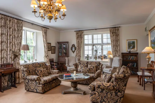 Indoor library with black and orange sofas and paintings on the wall