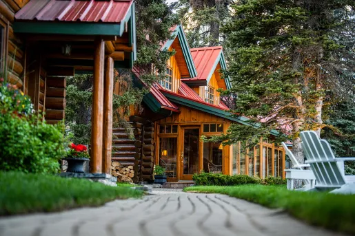 Wooden building with trees and lawn chairs on the right