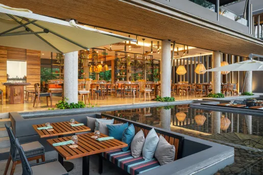 Outdoor lounge and dining area, with large pillars leading to an indoor dining area