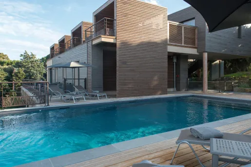 Outdoor pool with wooden walkways and metal, reclining chairs