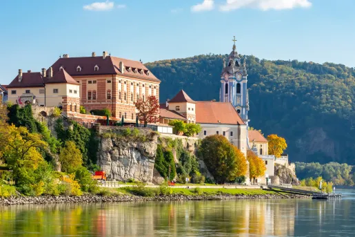 Large buildings on a small cliff overlooking a port