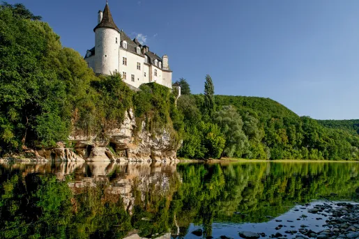 lakeside view of stone building on a cliff