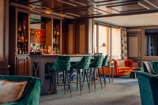 3 green chairs at a bar