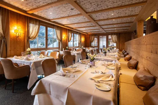 Indoor dining area with cushioned benches and cloths over each table