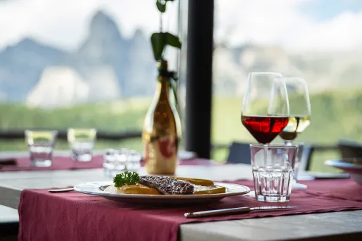Dining table with a vase in the center and filled glasses of wine