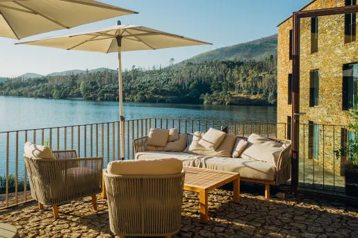 Couch and chairs under an umbrella on the balcony