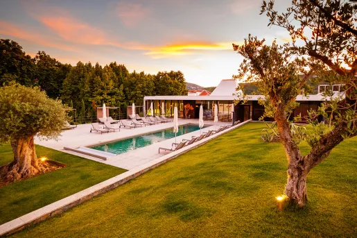 hotel pool surrounded by lounge chairs at sunset