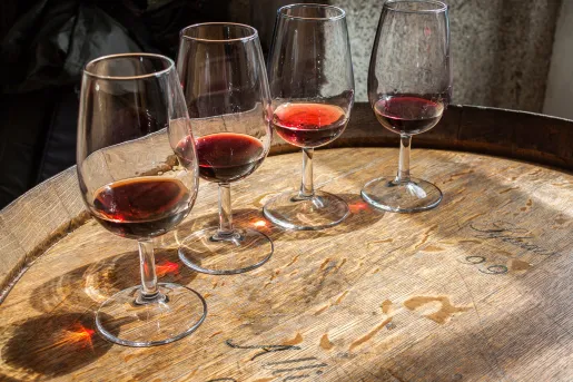 Four glasses of wine on top of a barrell