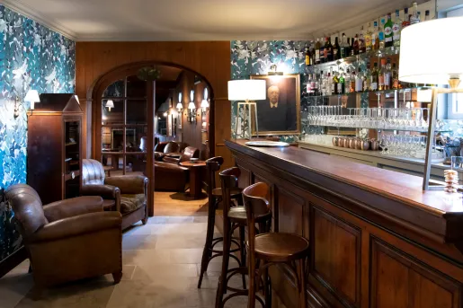 mahogany bar with barstools and stuffed chairs