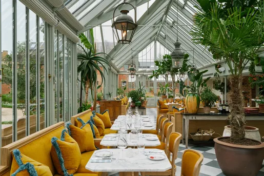 Indoor dining area with large open windows and orange couches