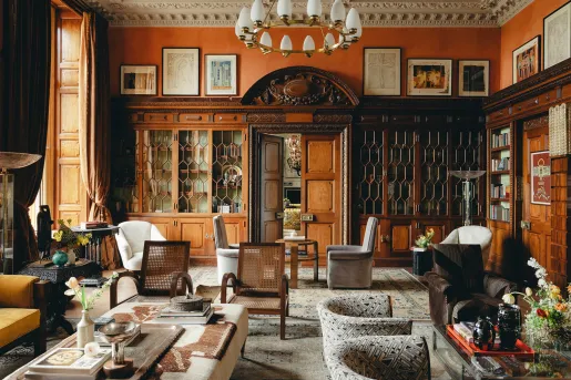 Indoor lounge with cushioned white chairs and tables 