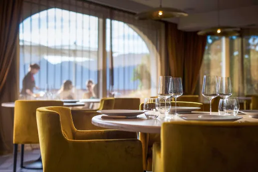 Indoor dining area with yellow cushioned chairs and wine glasses on the tables