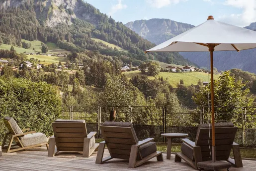 Outdoor balconies with an umbrella and brown cushioned chairs