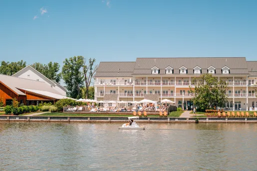Outdoor view of large, white building with balconies looking out to a boat in the ocean