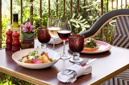 Dining table outdoors with plates of food and full glasses of wine
