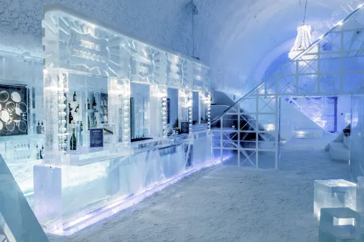 A liquor bar made of shaped ice, inside on an igloo-style room