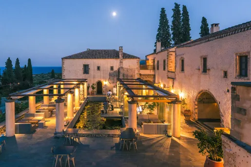 Outdoor lounge area with tall white pillars and orange lights