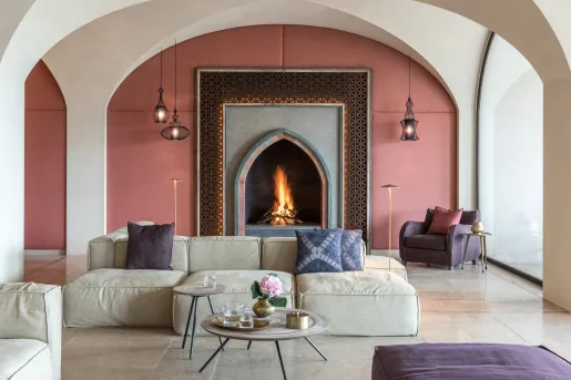 Indoor lounge with cushioned seats and a wood fireplace