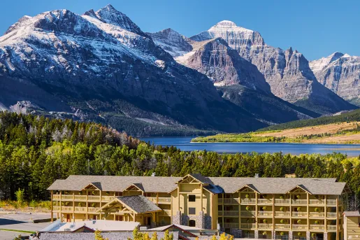 Long yellow hotel building with tall mountains in the background