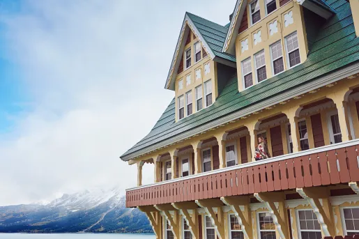 Large hotel building with an open balcony and a woman standing