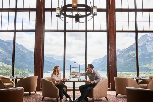 Man and woman in an open lounge sharing tea and pastries