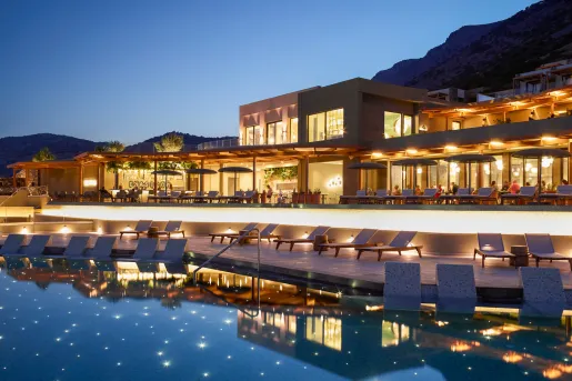 Hotel with bright orange lights with a pool in the center