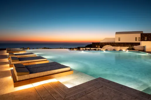 Outdoor infinity pool with beds along the perimeter