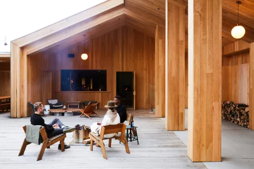 Three people sitting in an open wooden patio