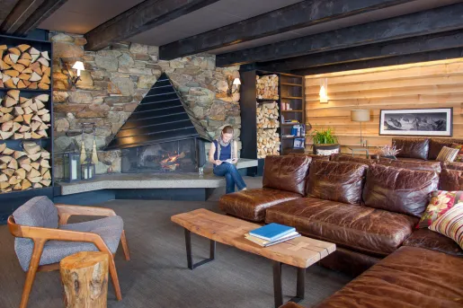 leather couches in front of stone fireplace