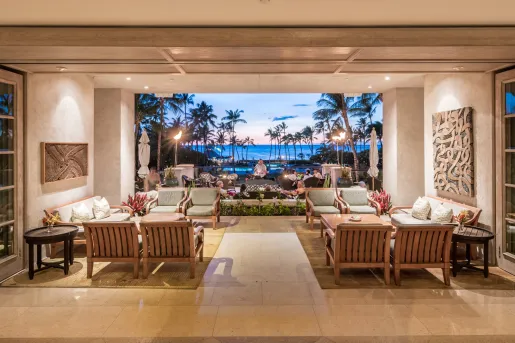 Lobby with a man playing a guitar in the background and the ocean behind him