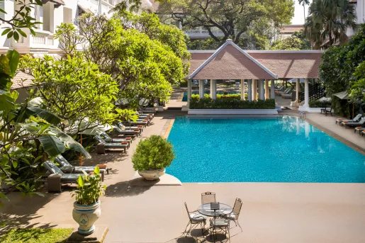Outdoor swimming pool surrounded by reclining pool chairs