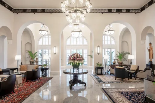 Hotel lobby with chairs on either side and a table with a vase in the center