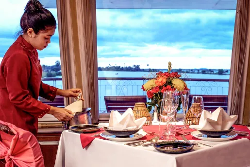 Woman in a red dress pulling out a bottle of wine from a chilled bucket