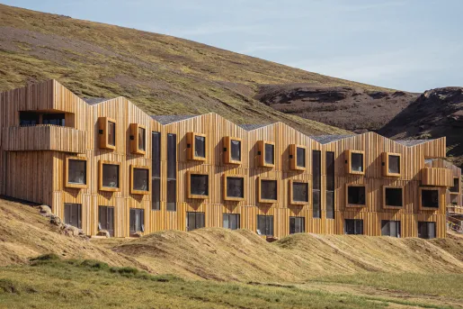 Hotel building made of wooden panels, with large open windows