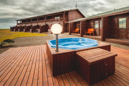 Outdoor hot tub on a wooden platform, next to a lodge building