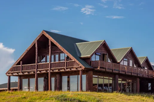 Outdoor view of wooden lodge with a green roof