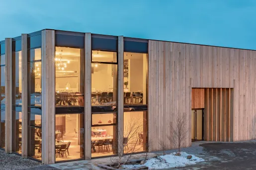 Wooden building with two stories of a dining hall with large, glass walls