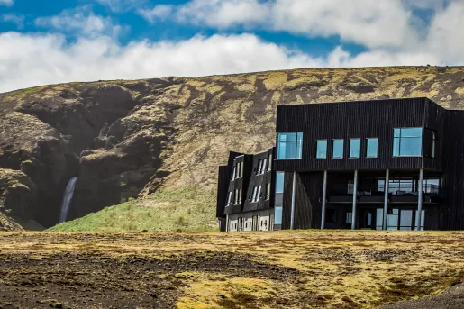Black building with large, glass windows in the middle of a dried valley